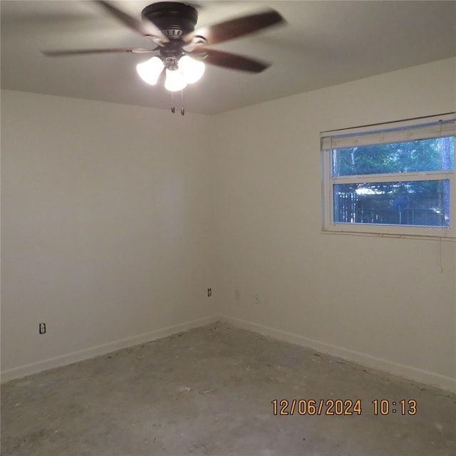 empty room with ceiling fan and concrete flooring