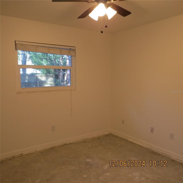 unfurnished room with ceiling fan and concrete floors