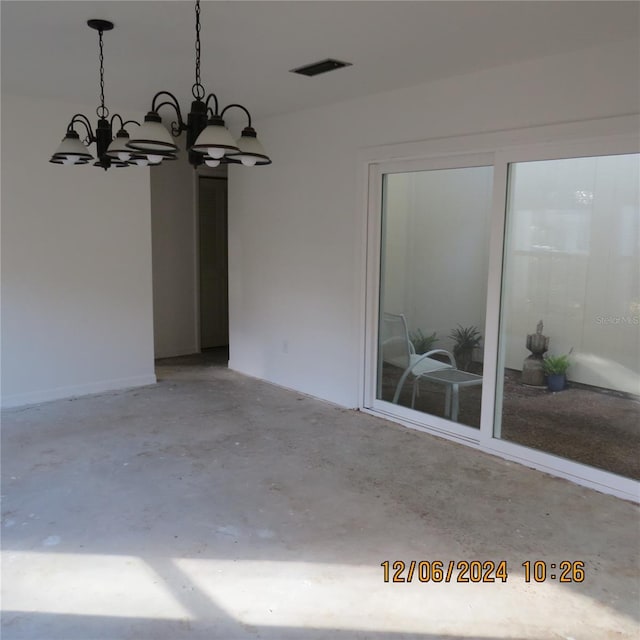 interior space featuring a chandelier and concrete floors