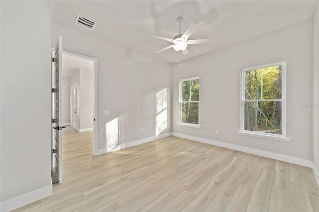 spare room with ceiling fan, a wealth of natural light, and light hardwood / wood-style flooring