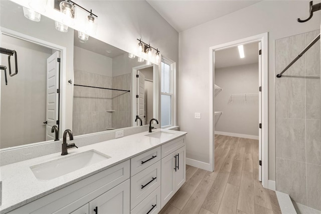 bathroom featuring tiled shower, vanity, and hardwood / wood-style flooring