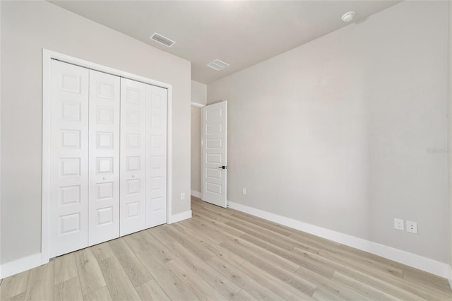 unfurnished bedroom with light hardwood / wood-style flooring and a closet