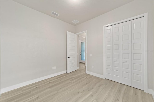 unfurnished bedroom featuring light hardwood / wood-style floors and a closet