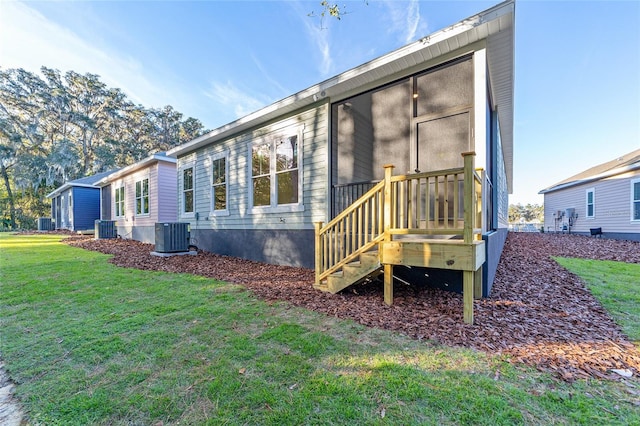 back of property with a lawn and cooling unit