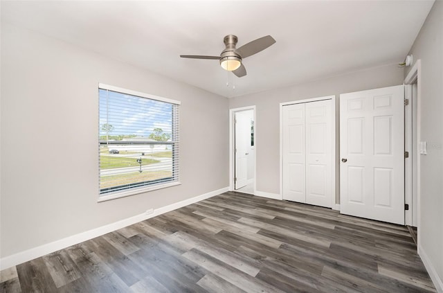 unfurnished bedroom with a closet, ceiling fan, and dark wood-type flooring