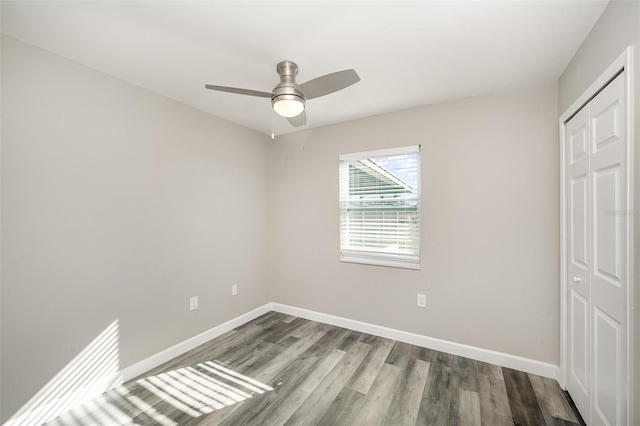 unfurnished bedroom featuring ceiling fan, a closet, and hardwood / wood-style flooring