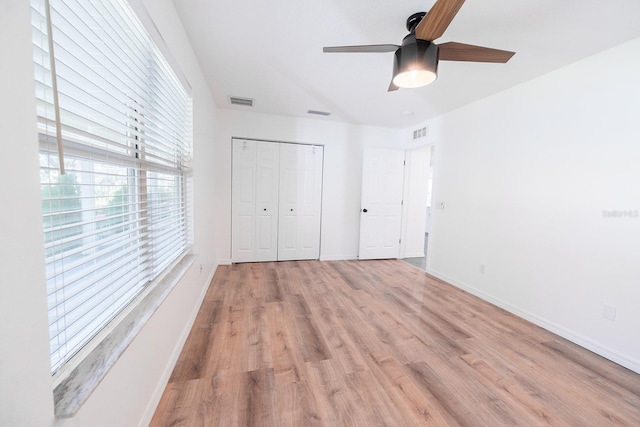 unfurnished bedroom featuring ceiling fan, a closet, and light hardwood / wood-style floors