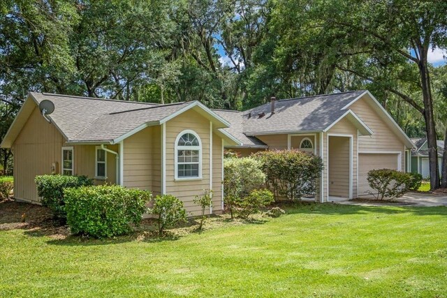 ranch-style house featuring a front yard and a garage