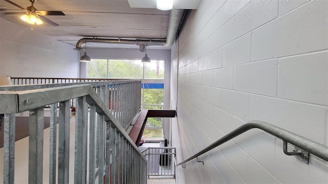 staircase featuring ceiling fan