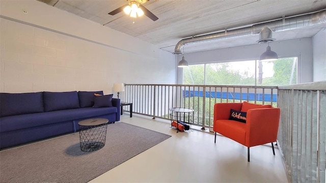 living room with ceiling fan and concrete flooring