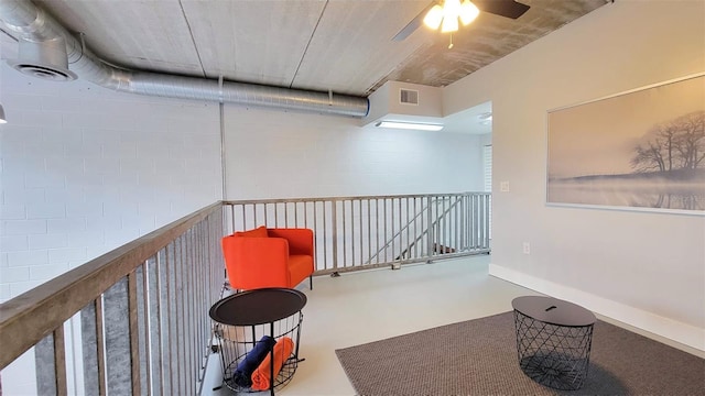 sitting room with ceiling fan and concrete floors