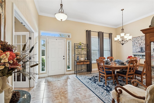 tiled entrance foyer featuring ornamental molding and a notable chandelier