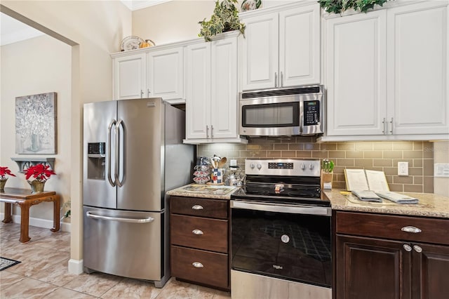 kitchen featuring decorative backsplash, white cabinetry, and stainless steel appliances