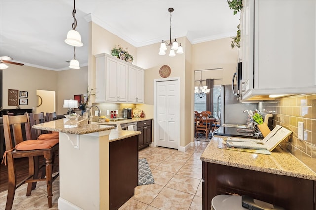 kitchen with crown molding, white cabinetry, a breakfast bar, and hanging light fixtures