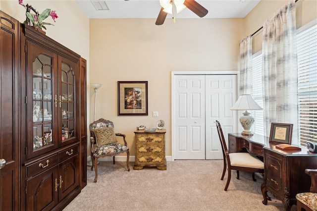 carpeted home office with a wealth of natural light and ceiling fan