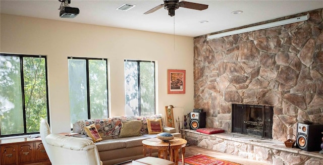 living room with ceiling fan and a fireplace