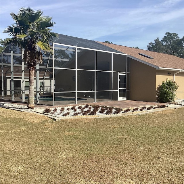 view of side of property with a patio, a lanai, and a lawn