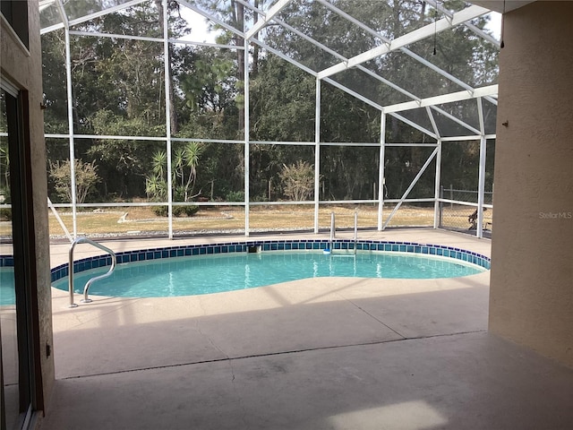 view of pool featuring a patio and glass enclosure