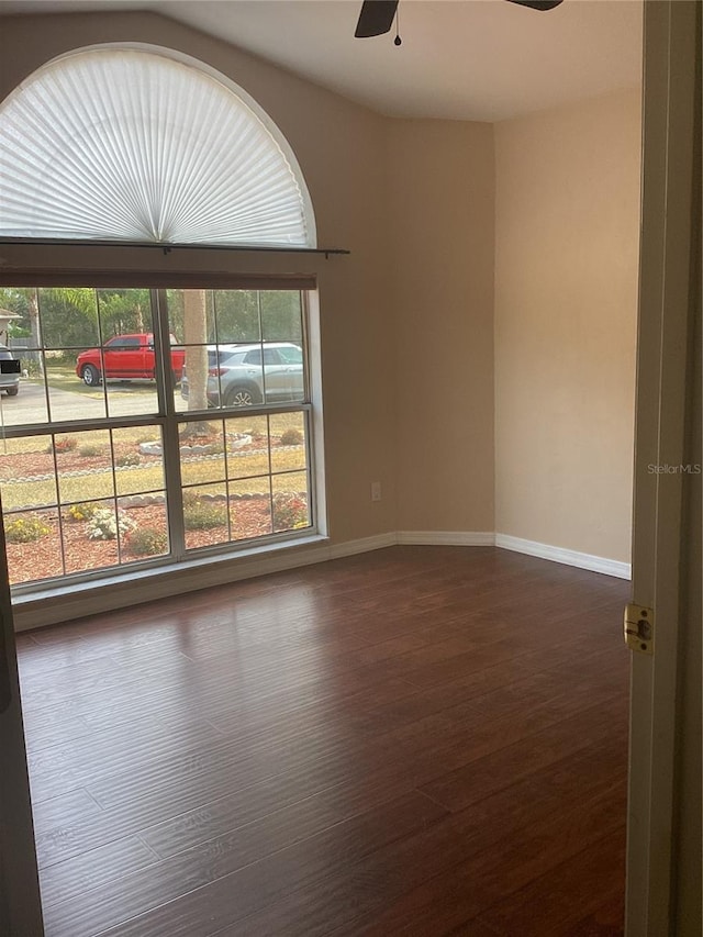 unfurnished room with ceiling fan and dark wood-type flooring