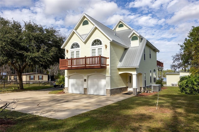 view of front of home with cooling unit, a garage, and a front yard