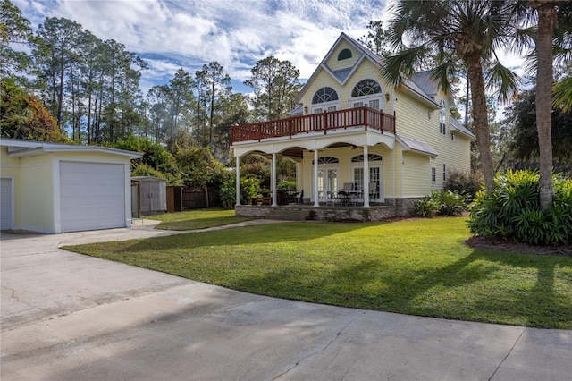 view of front of home featuring a garage, a balcony, a shed, a front lawn, and covered porch