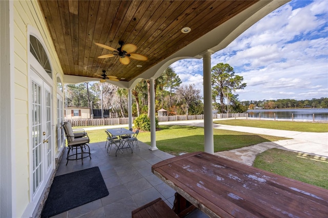 view of patio with ceiling fan and a water view