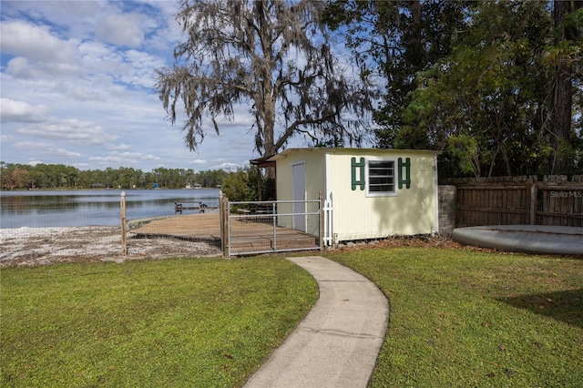 view of outbuilding with a lawn and a water view