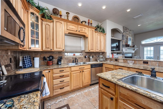 kitchen with light stone counters, light tile patterned floors, sink, and appliances with stainless steel finishes