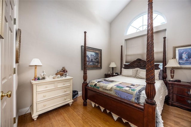 bedroom featuring hardwood / wood-style floors and high vaulted ceiling