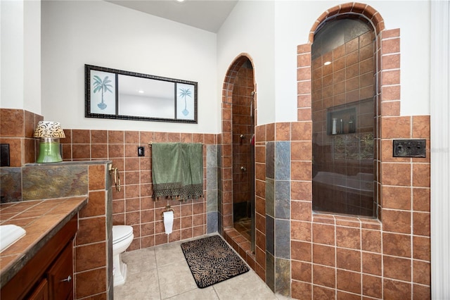 bathroom with tile patterned floors, vanity, toilet, and tile walls