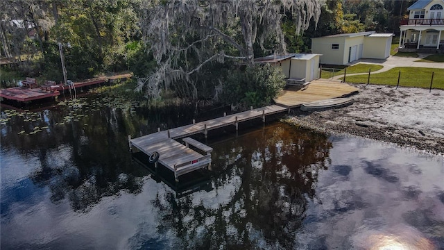 view of dock with a water view and a yard