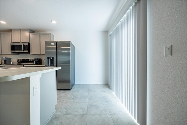 kitchen featuring gray cabinets, light tile patterned floors, and appliances with stainless steel finishes