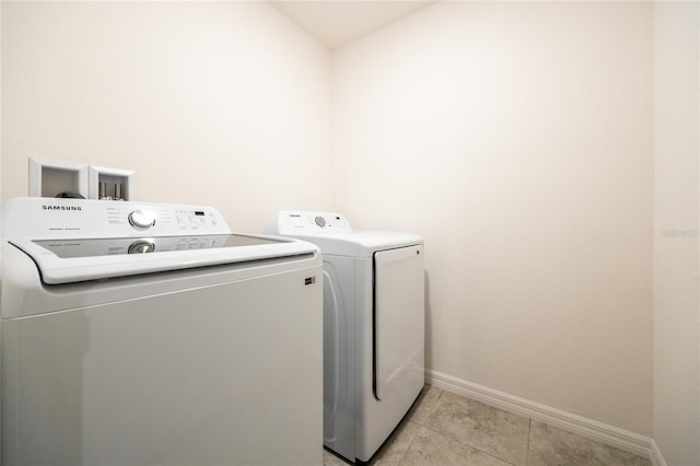 laundry room with light tile patterned floors and washing machine and clothes dryer