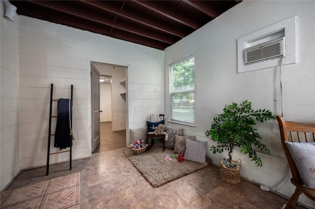 interior space featuring beamed ceiling and a wall mounted AC