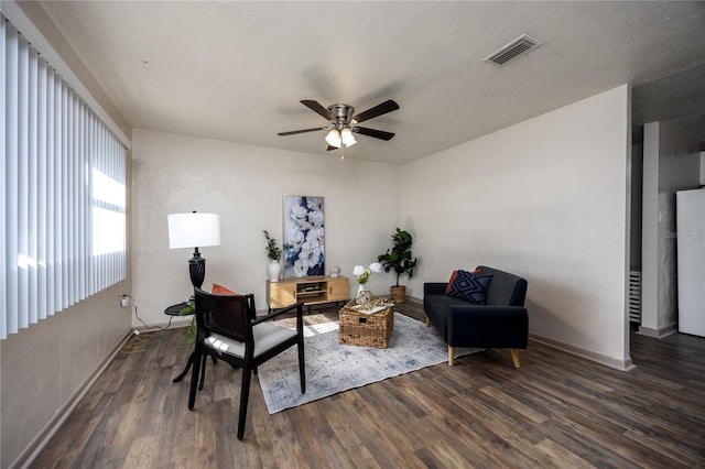 living area featuring dark hardwood / wood-style floors and ceiling fan