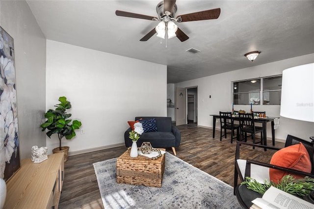 living room featuring a textured ceiling, dark hardwood / wood-style flooring, and ceiling fan