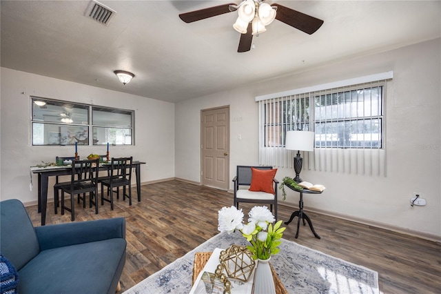 living room featuring ceiling fan and dark hardwood / wood-style flooring