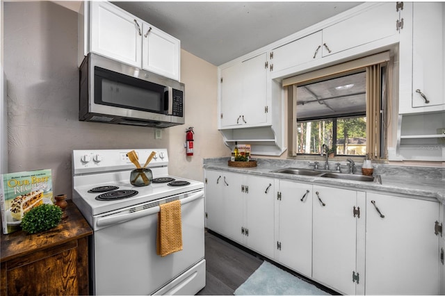 kitchen featuring white electric range oven, dark hardwood / wood-style flooring, white cabinetry, and sink