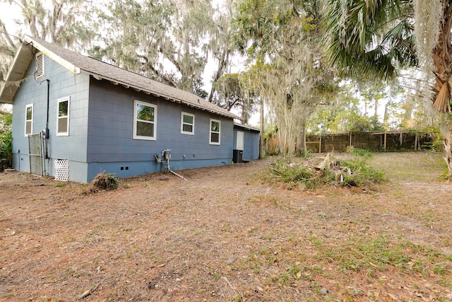 rear view of property with crawl space and fence