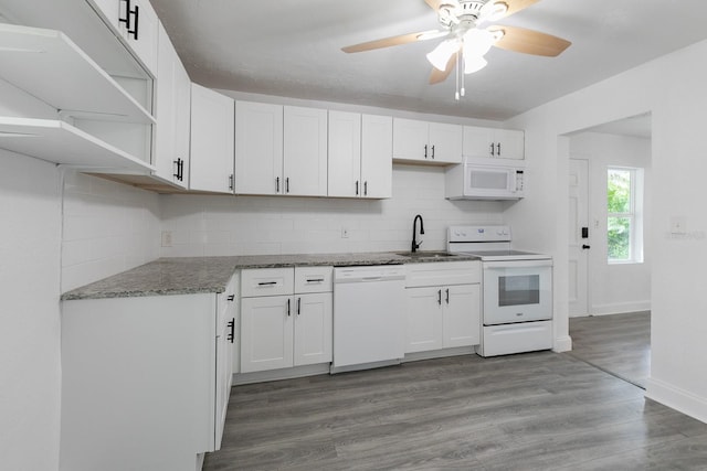 kitchen featuring light wood-type flooring, white appliances, tasteful backsplash, and a sink