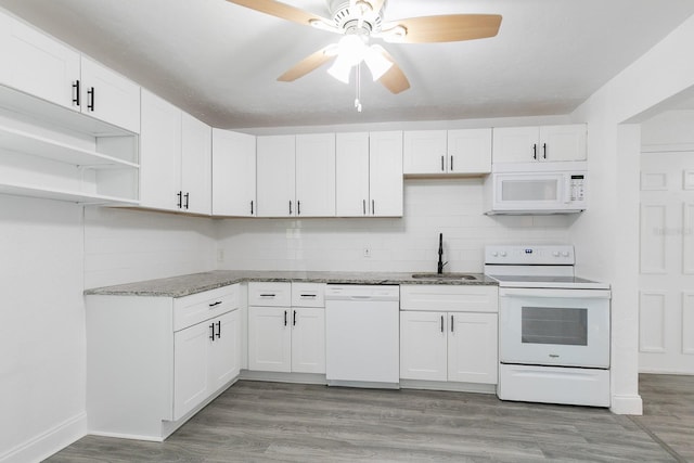 kitchen with backsplash, light wood-style floors, white cabinets, a sink, and white appliances