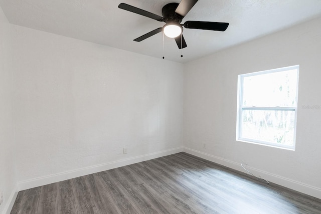 spare room featuring wood finished floors and baseboards