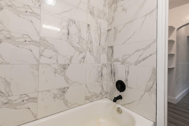 bathroom with shower / bath combination and wood finished floors