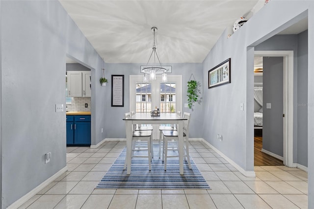 unfurnished dining area with a notable chandelier and light tile patterned floors