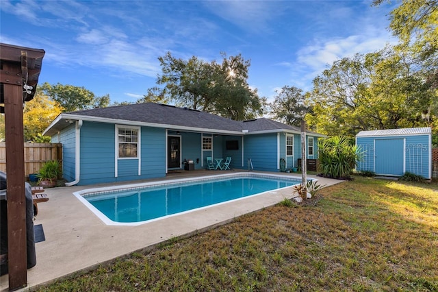 view of swimming pool featuring a patio, a storage unit, and a lawn