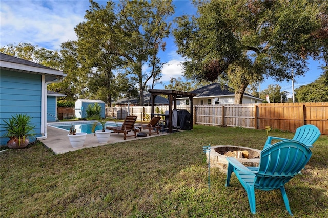 view of yard featuring a fenced in pool, a fire pit, and a storage shed