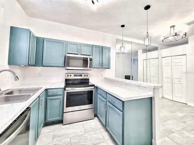 kitchen with kitchen peninsula, stainless steel appliances, blue cabinets, sink, and hanging light fixtures