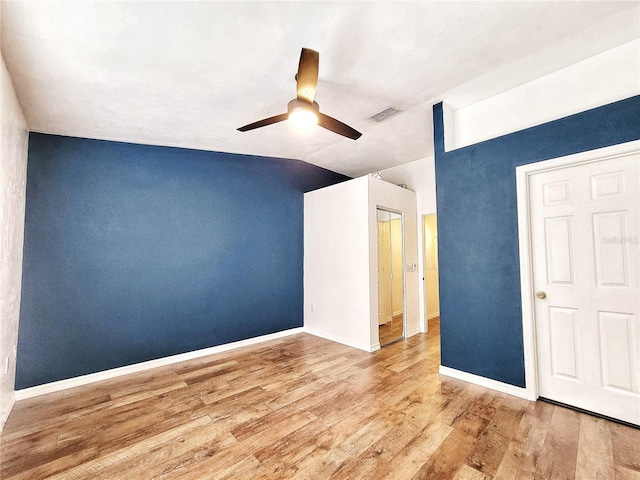 unfurnished room featuring hardwood / wood-style flooring, vaulted ceiling, and ceiling fan