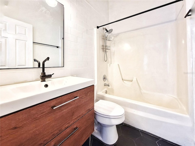 full bathroom featuring washtub / shower combination, tile patterned floors, toilet, vanity, and tile walls