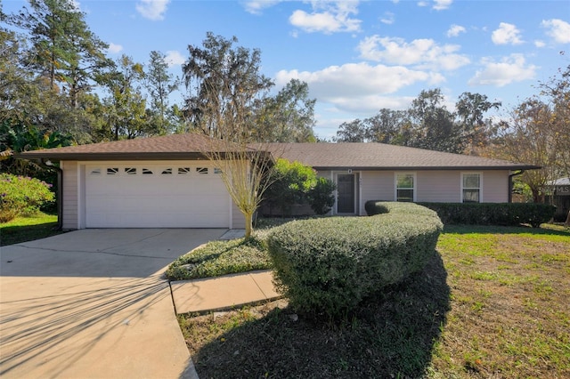 single story home with a garage and a front lawn